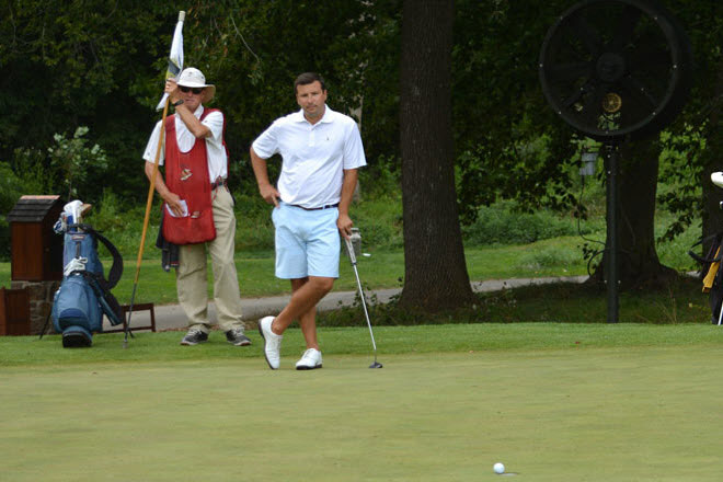 Tom Spano discusses his putt with his caddie.